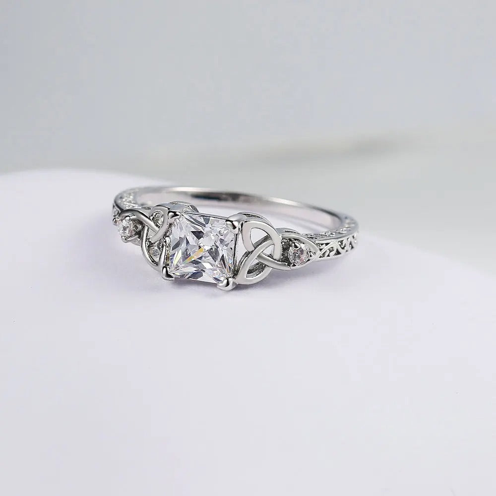 Prsten s uzlovým designem a drahokamem ve střední části